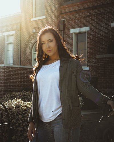 女人在灰色夹克站在黑色的自行车
